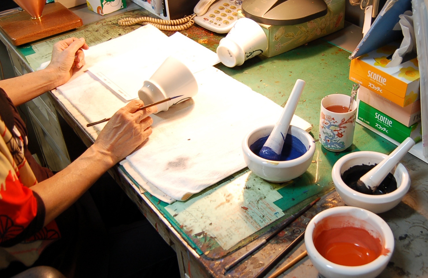 Artisan hand-painting Akae overglaze enamels