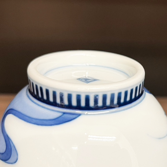 Close-up of a comb-patterned foot ring on a Nabeshima-style teacup