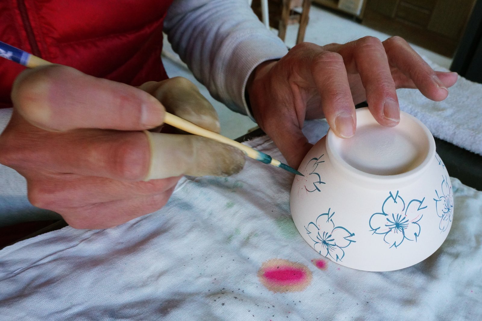 Artisan creating detailed Sometsuke decoration with fine brush lines