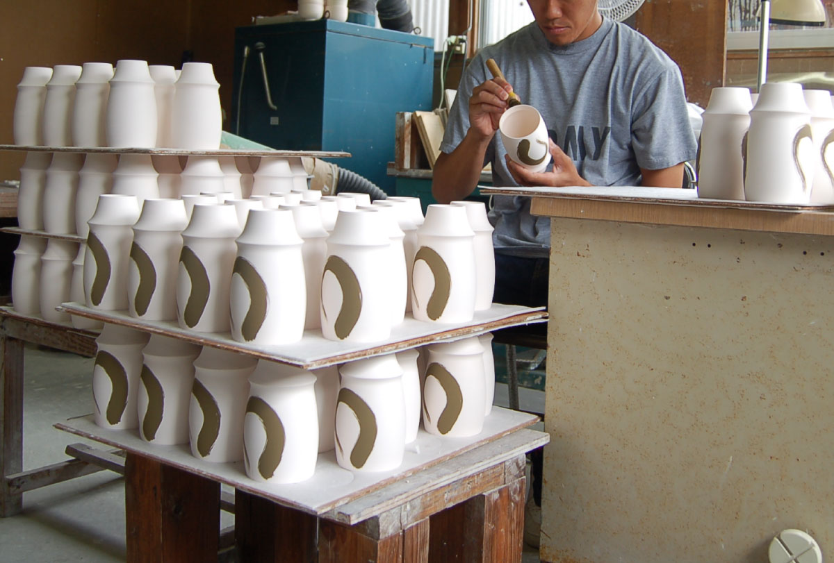 Artisan painting Sometsuke decoration with gosu on a bisque-fired cup